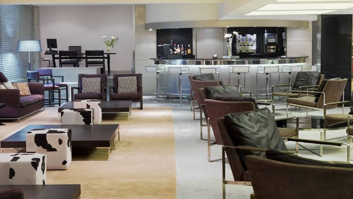 Hotellobby des H10 Gran Tinerfe mit Bar, Sofas und Stühlen.