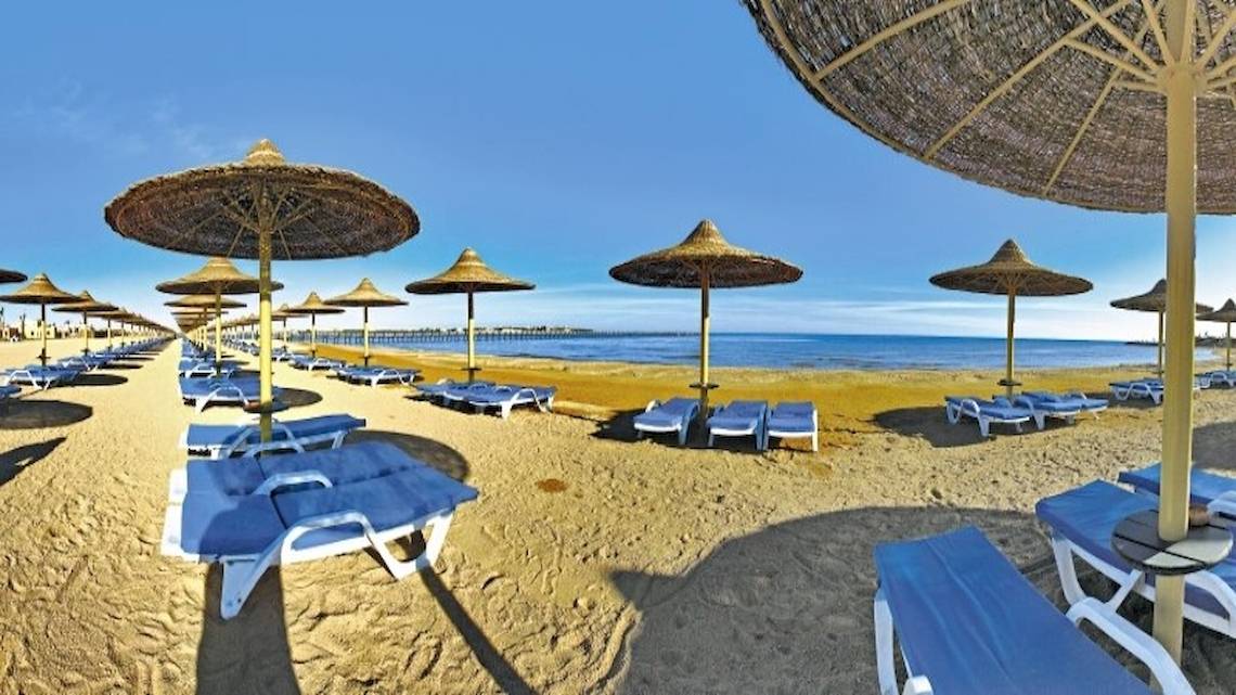 Strand des Stella Gardens Resort & Spa Makadi Bay mit Liegen und Sonnenschirmen.