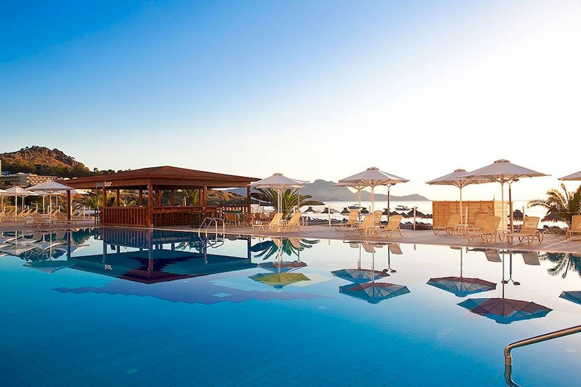 Pool-Terrasse des Lindos Bay Hotels mit Sonnenschirmen und Liegen am Meer