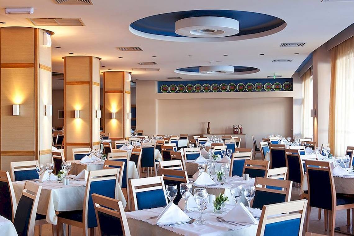 Innenbereich des Lindos Bay Hotels mit eingerichteten Tischen und Stühlen.
