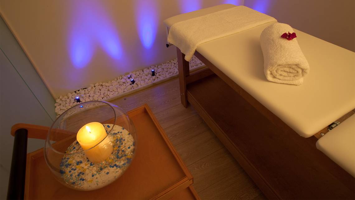 Relaxationsbereich im Silva Beach Hotel mit Massageliege, Kerze und Steinen