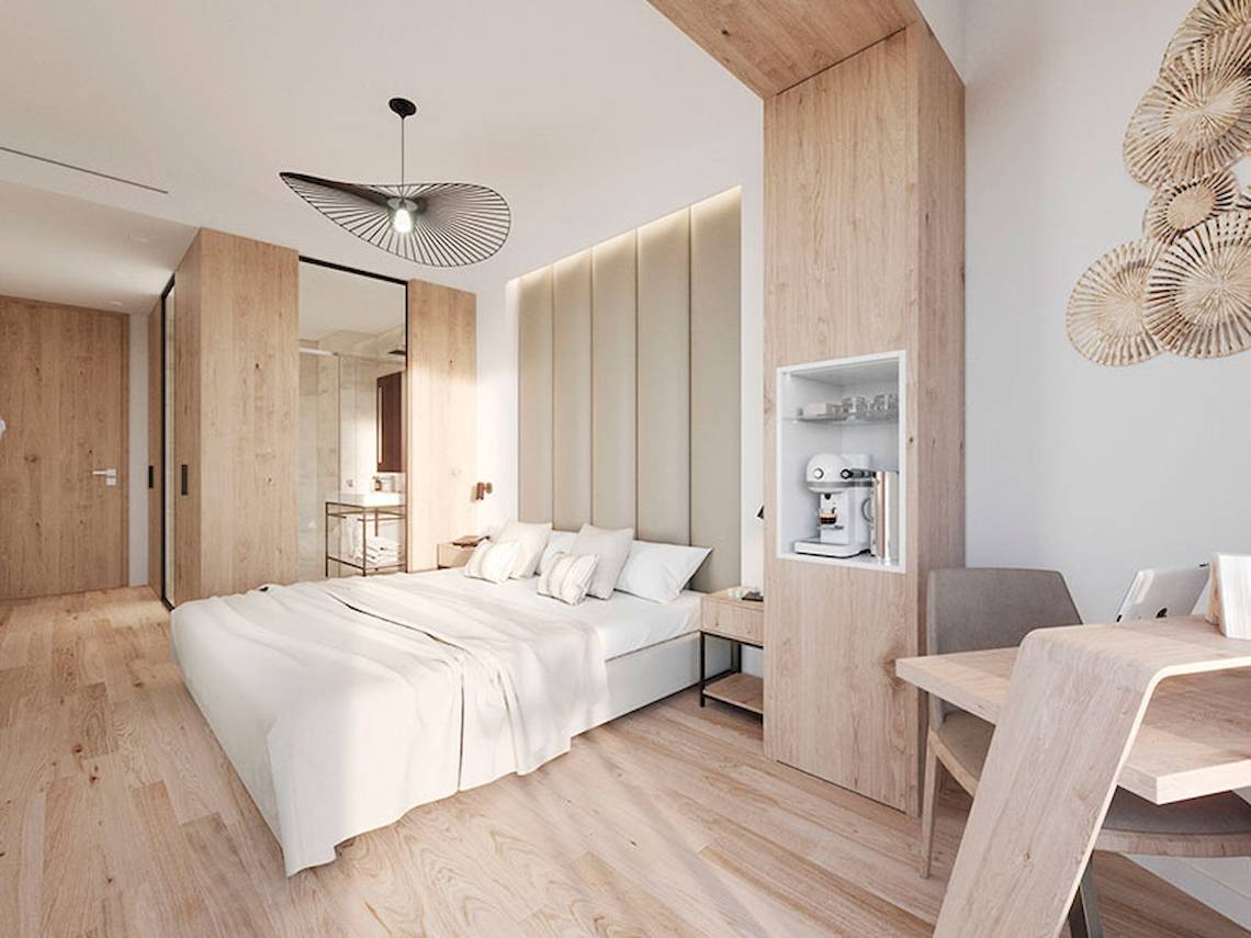Ein modernes Hotelzimmer mit einem Bett, Schreibtisch und Kaffeemaschine.