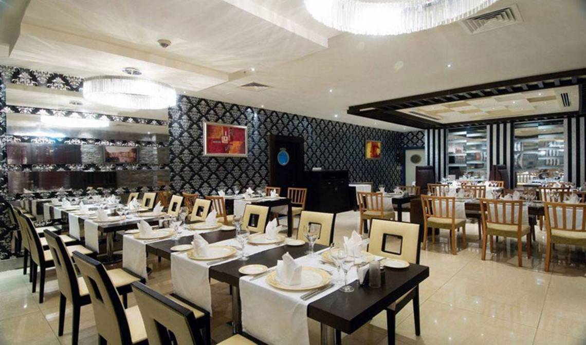 Innenansicht des Restaurants im Orange County Belek - Family Concept Hotel mit gedeckten Tischen und Stühlen.