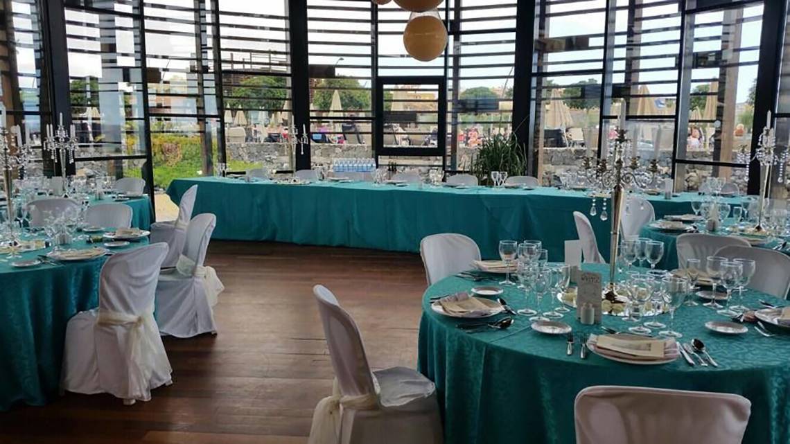 Bankettsaal im Barcelo Tenerife mit türkisfarbenen Tischdecken und weißen Stühlen.