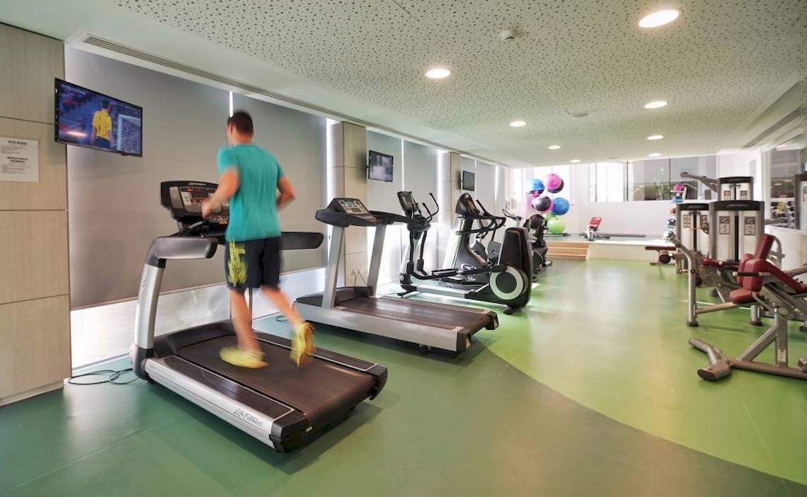 Fitnesscenter im Melissi Beach Hotel & Spa mit einem Mann, der auf einem Laufband läuft.