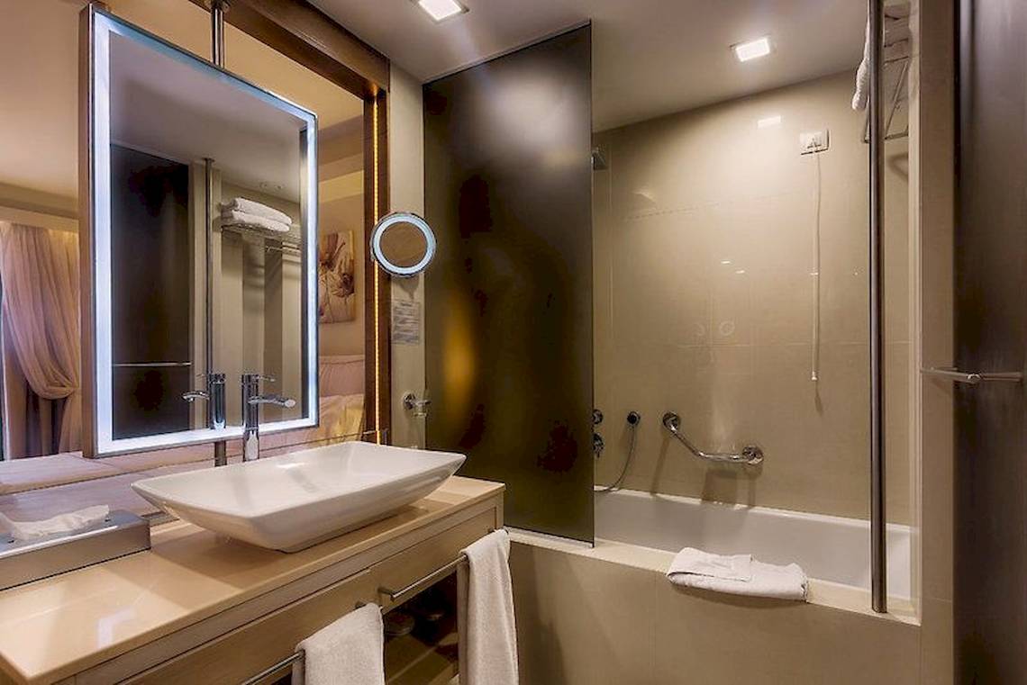 Badezimmer des Aegean Pearl Hotels mit Waschbecken, Spiegel und Badewanne