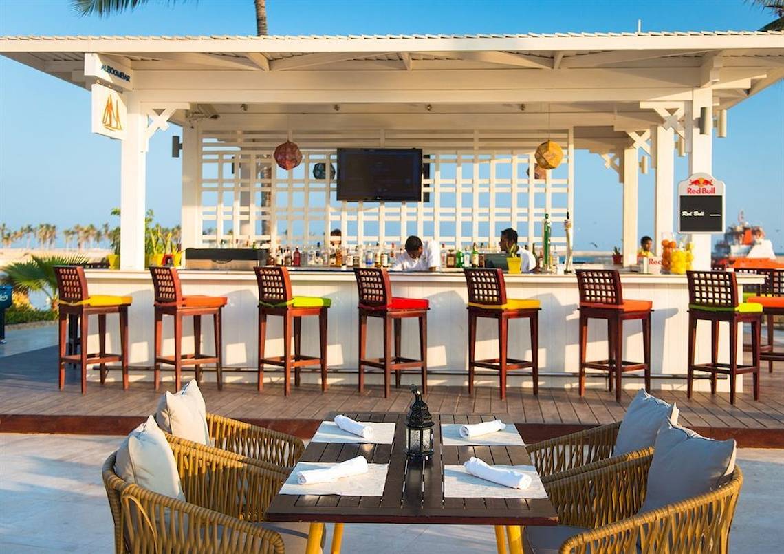 Terrassenbar des Juweira Boutique Hotels mit Stühlen und Tischen im Freien.