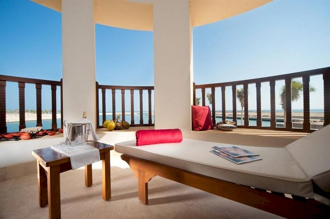Blick vom Balkon des Juweira Boutique Hotels mit Loungemöbeln, Kissen und Meersicht