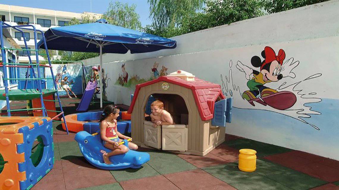 Zwei Kinder spielen auf einem Spielplatz im Freien im Anonymous Beach Hotel.