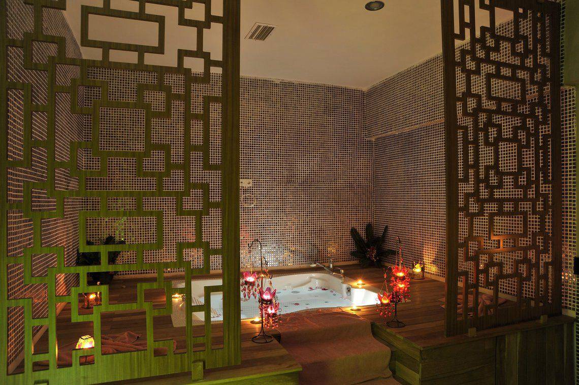 Wellnessbereich im Seaden Corolla Hotel mit Jacuzzi und dekorativen Kerzen.