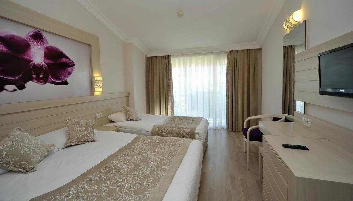 Doppelzimmer im Seaden Corolla Hotel mit zwei Betten, Fernseher und Dekor.