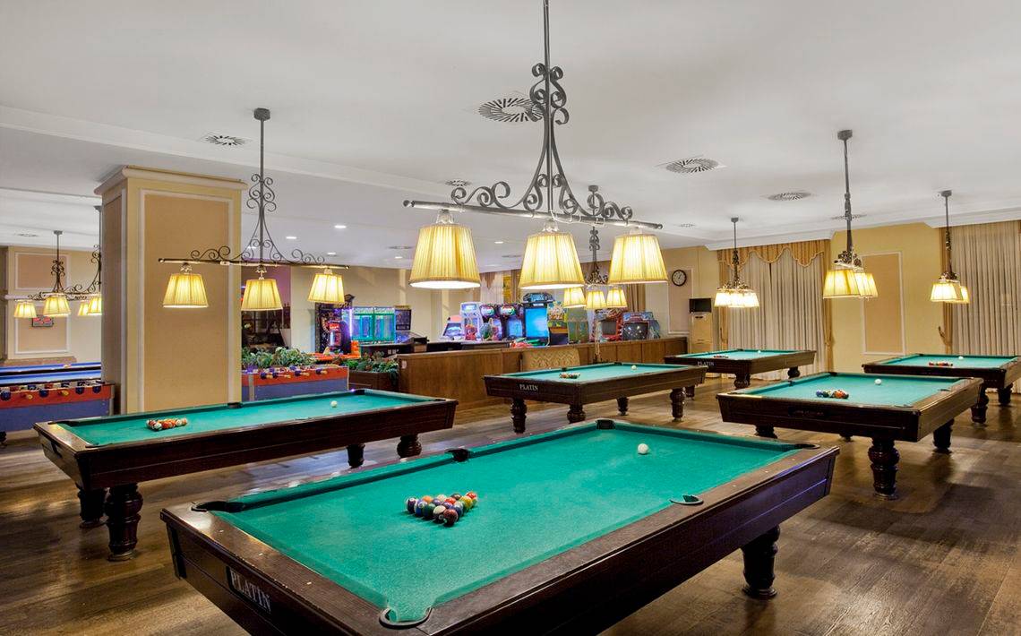 Billardsaal im Kremlin Palace Hotel mit mehreren Billardtischen und Spielgeräten.