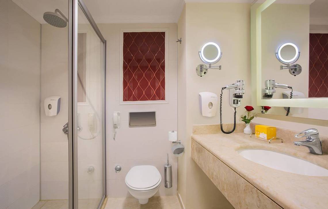 Badezimmer des Kremlin Palace Hotels mit Dusche, Toilette und Waschbecken.