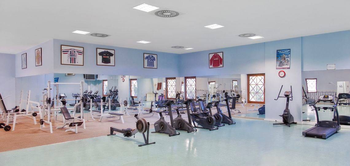 Fitness-Center im Kremlin Palace Hotel mit verschiedenen Trainingsgeräten und Spiegeln.