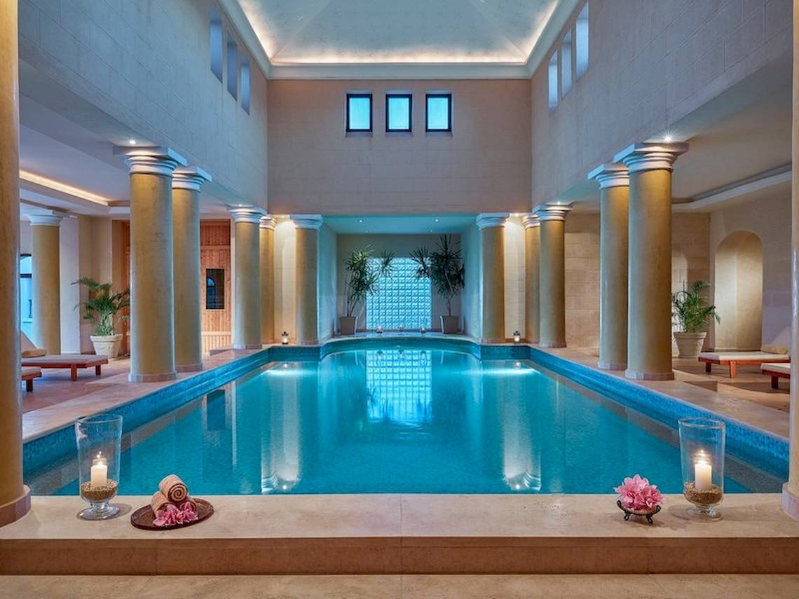 Indoor-Pool im Jaz Mirabel Beach Hotel mit Säulen, Lounge-Bereich und Kerzen