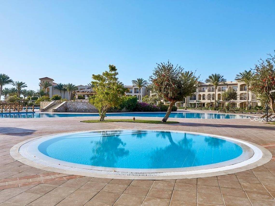 Außenpool im Jaz Mirabel Beach Hotel mit gepflastertem Bereich und Palmen