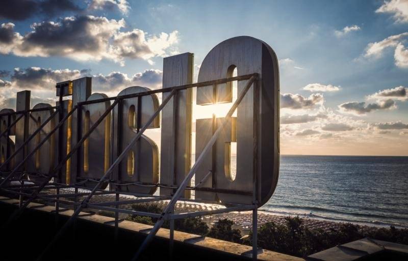 Schild des Gladiola Star Hotels am Meer bei Sonnenuntergang.