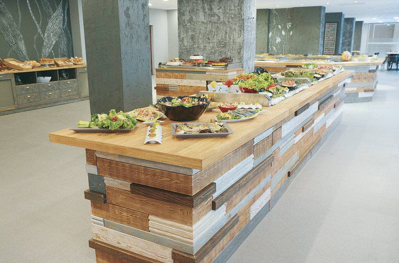Buffettisch im Gladiola Star Hotel mit verschiedenen Gerichten auf Holzplatte.