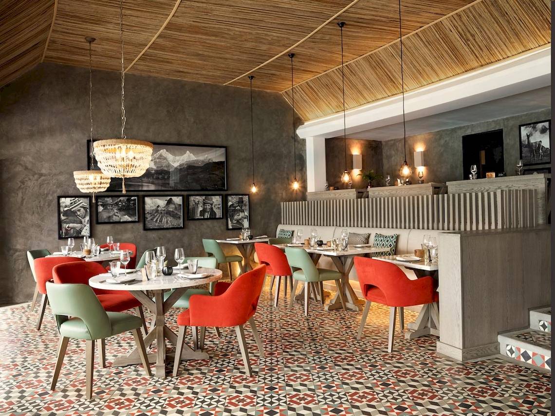 Innenansicht des Restaurants im LUX Grand Gaube Resort & Villas mit bunten Stühlen und Tischen.