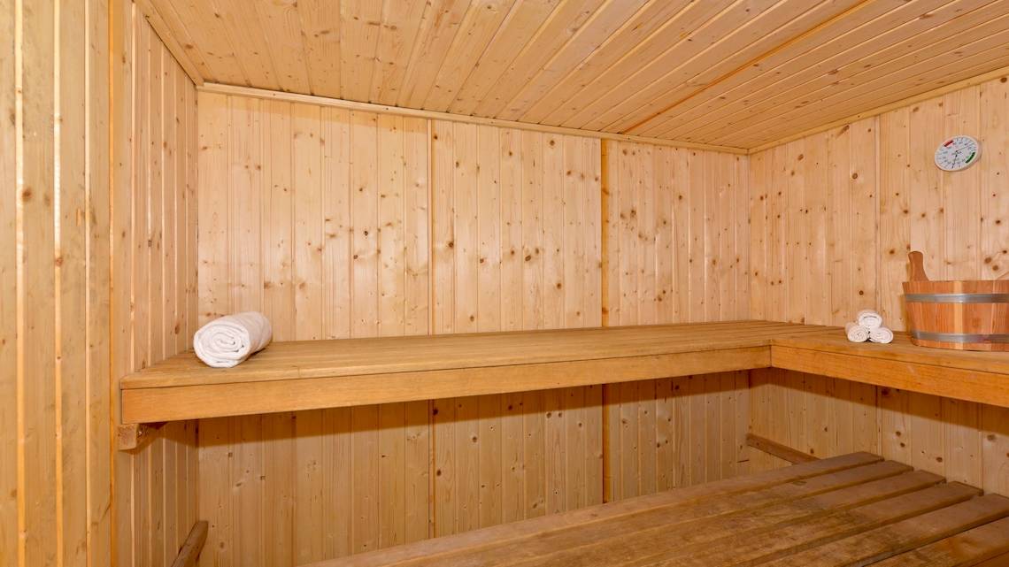 Saunaraum im Iberostar Tainos Hotel mit Holzwänden und zwei Bänken, auf denen Handtücher liegen.