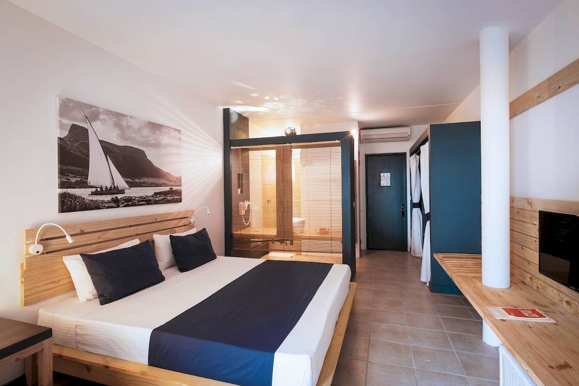 Innenansicht eines Hotelzimmers im Veranda Pointe Aux Biches mit Bett, Dekor und Badezimmer