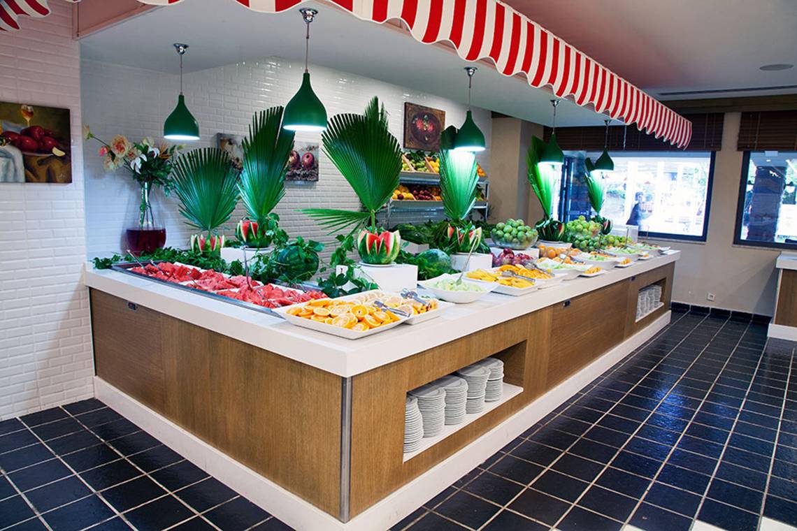 Buffet-Tisch im Belconti Resort mit verschiedenen Früchten und Gerichten.