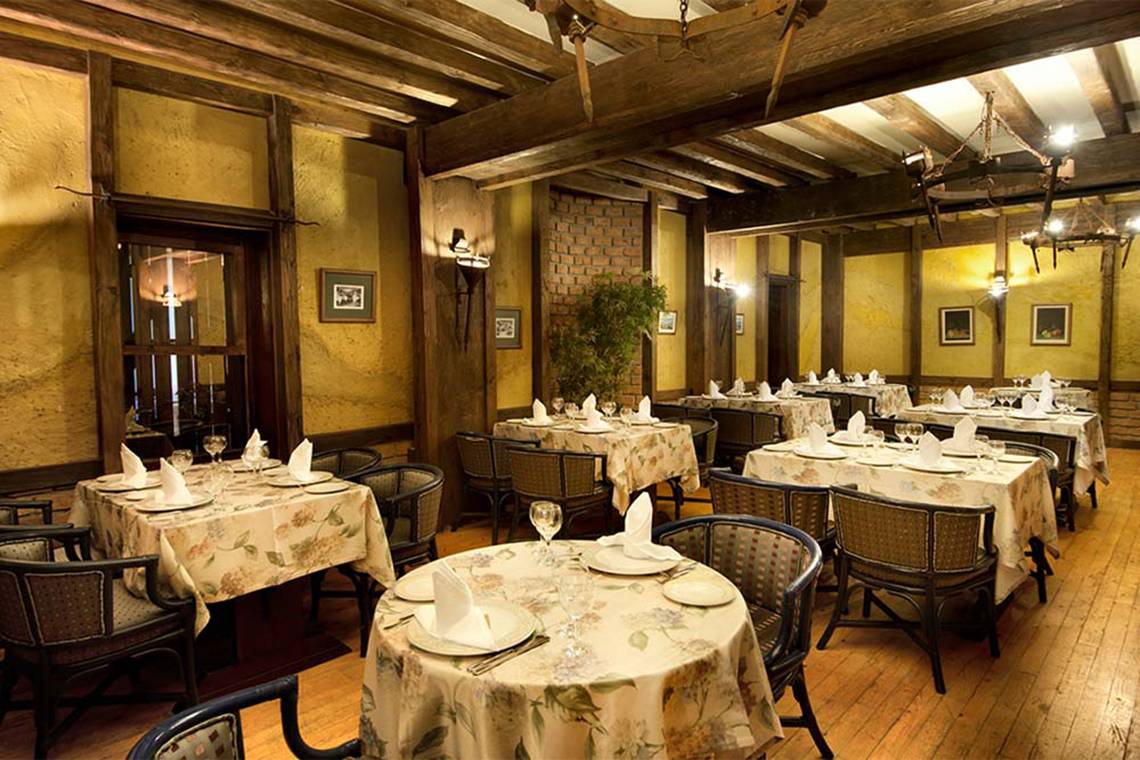Das Innere des Restaurants des Belconti Resorts mit gedeckten Tischen und Stühlen.