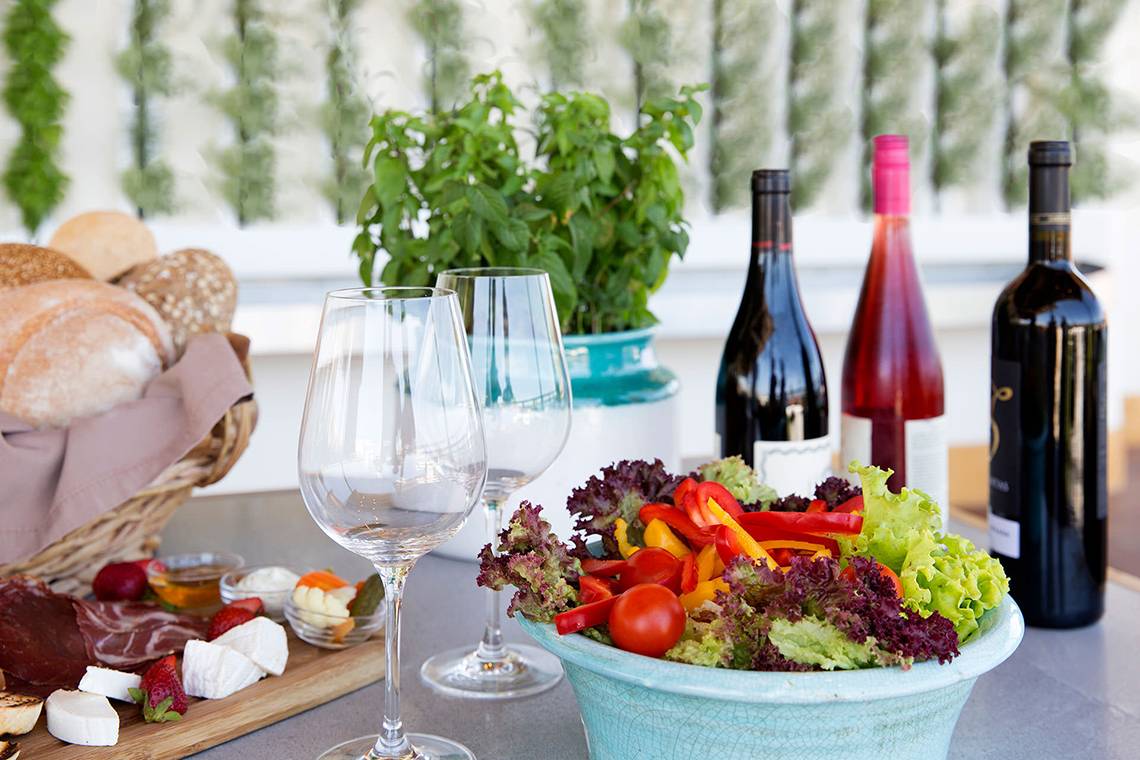 Tisch mit Brot, Salat, Wein und anderen Gerichten im Capo Bay Hotel