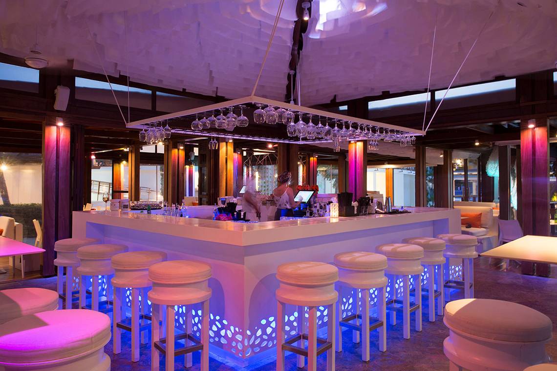 Bar im Capo Bay Hotel mit LED-Beleuchtung und Sitzgelegenheiten.