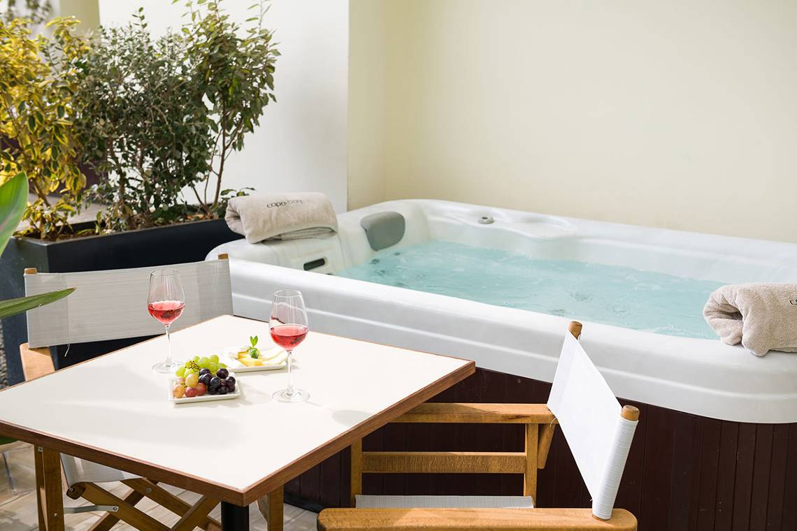 Jacuzzi im Capo Bay Hotel mit Tisch, Getränken und Obst