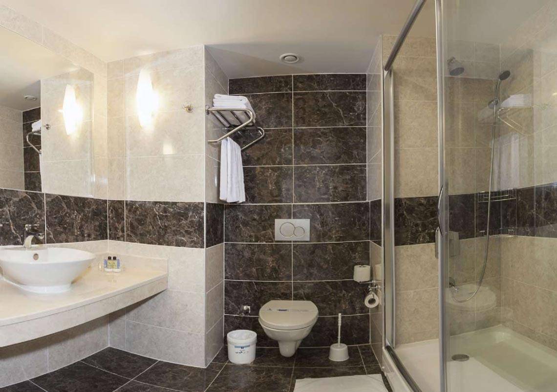 Badezimmer im Magic Life Belek Hotel mit schwarz-weißen Fliesen und einer Dusche.