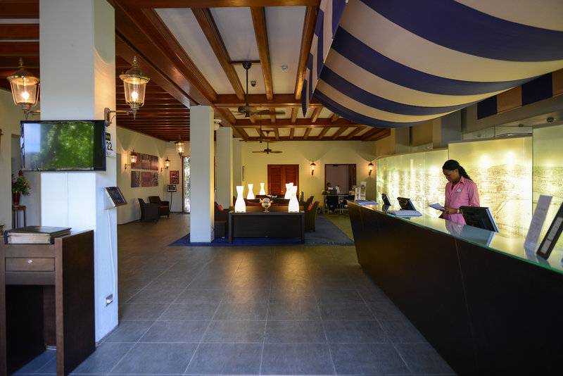 Empfangsbereich des Avila Beach Hotels mit Rezeptionistin und moderner Einrichtung.