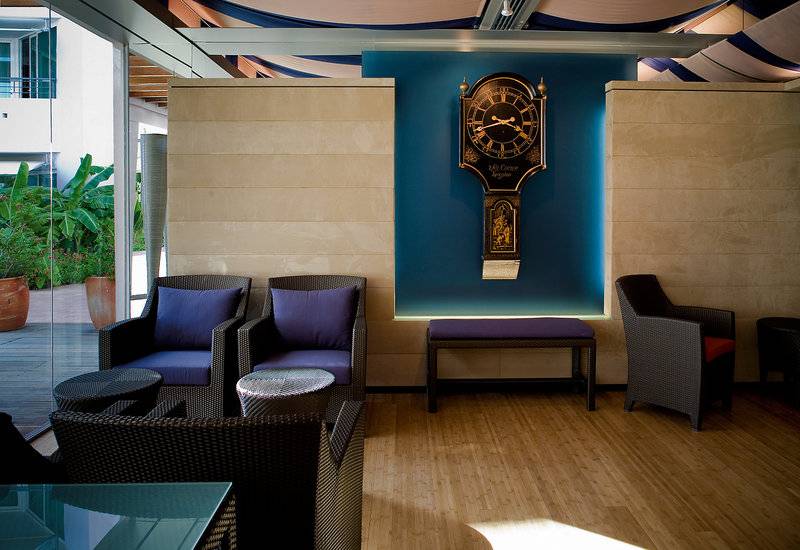 Loungebereich des Avila Beach Hotels mit Uhr an der Wand und Möbeln.
