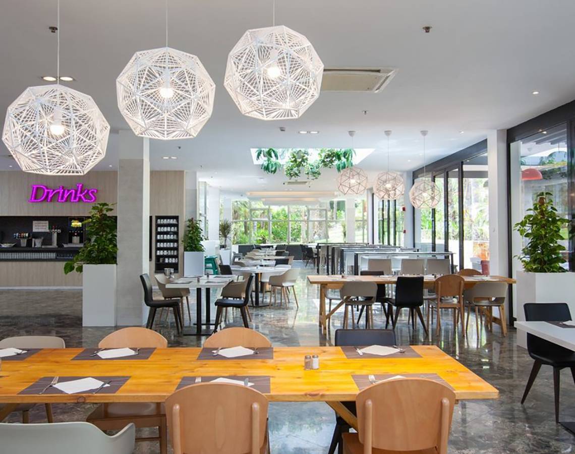 Frühstücksbereich im Abora Catarina Hotel mit modernen Möbeln und Pflanzen.