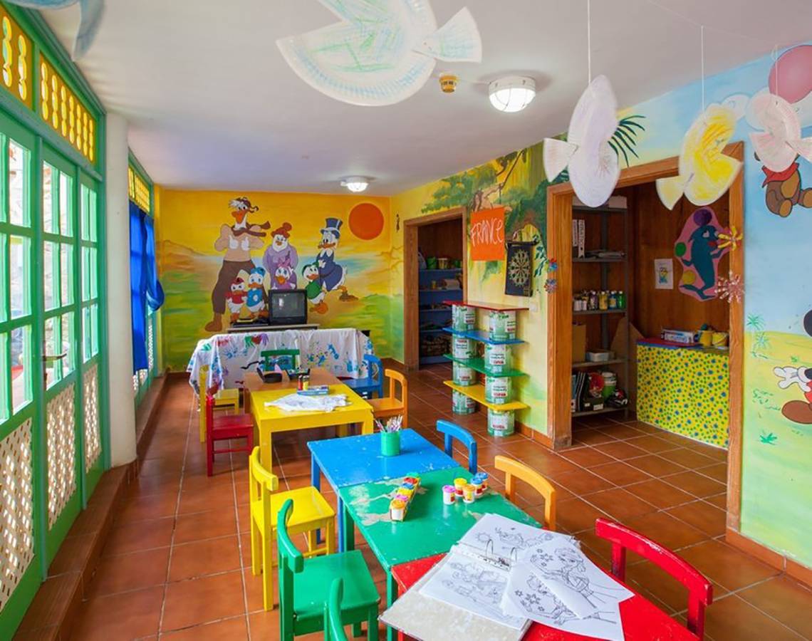 Innenansicht des Kinderzimmers im Abora Catarina Hotel mit bunten Tischen und Stühlen.