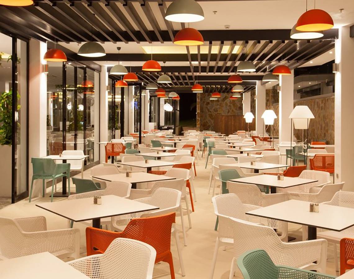 Innenansicht des Restaurants im Abora Catarina Hotel mit vielen bunten Stühlen und Tischen.