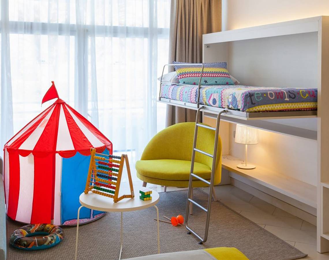 Kinderzimmer im Abora Catarina Hotel mit Doppelbett, Spielzelt und Spielzeug.