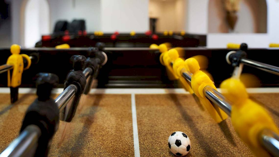 Foosballtisch im Acrotel Athena Pallas Hotel mit Ball und Spielern.