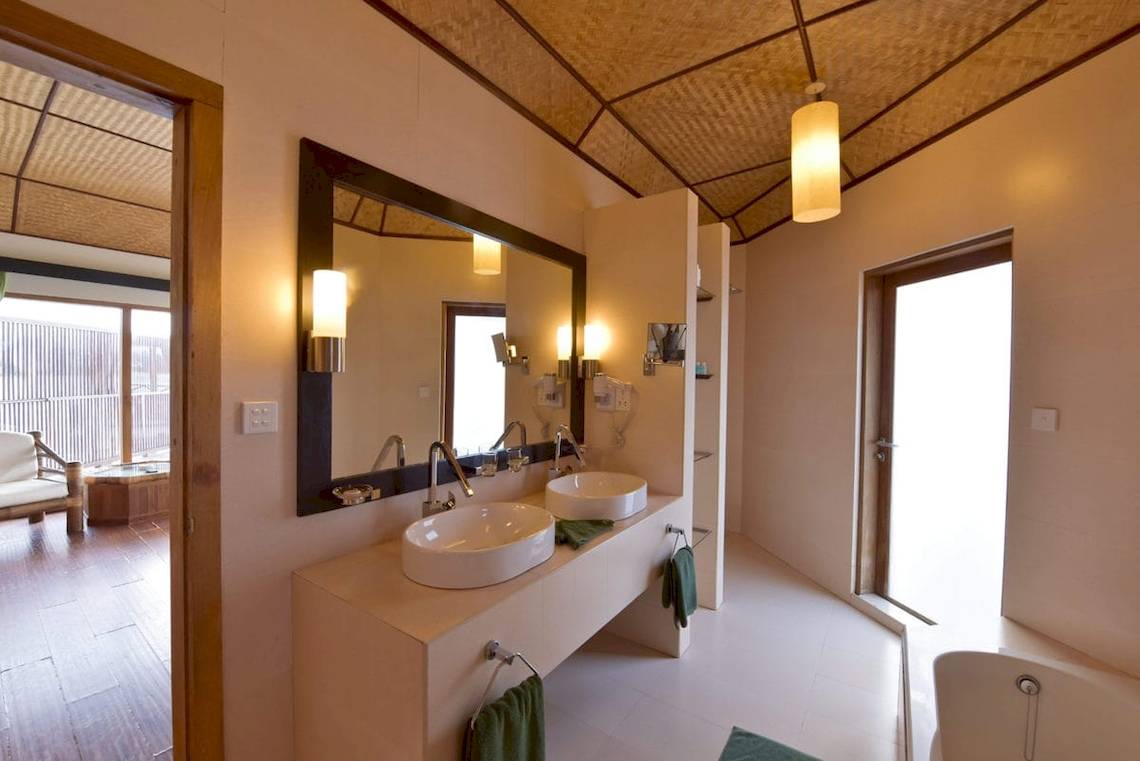 Ein Badezimmer des Safari Island Resorts mit zwei Waschbecken, einem Spiegel und einer Badewanne.