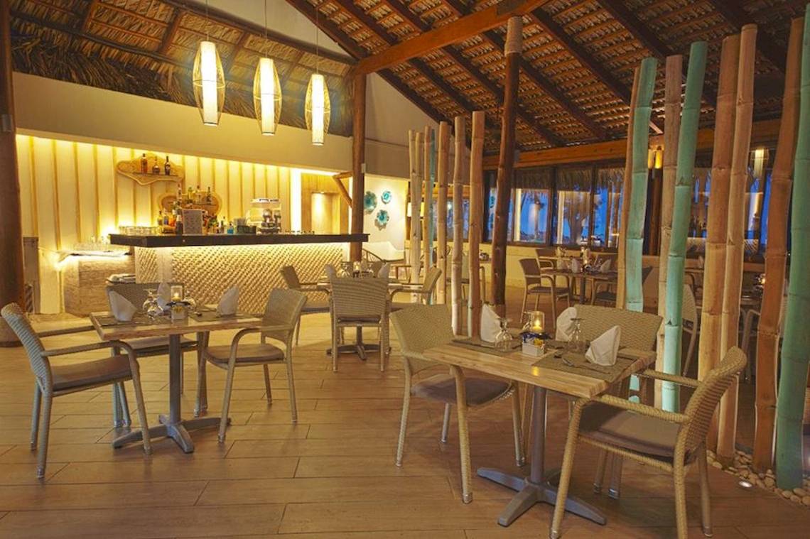 Innenbereich eines Restaurants im Vista Sol Punta Cana Beach Resort & Spa mit Tischen, Stühlen und Bar.