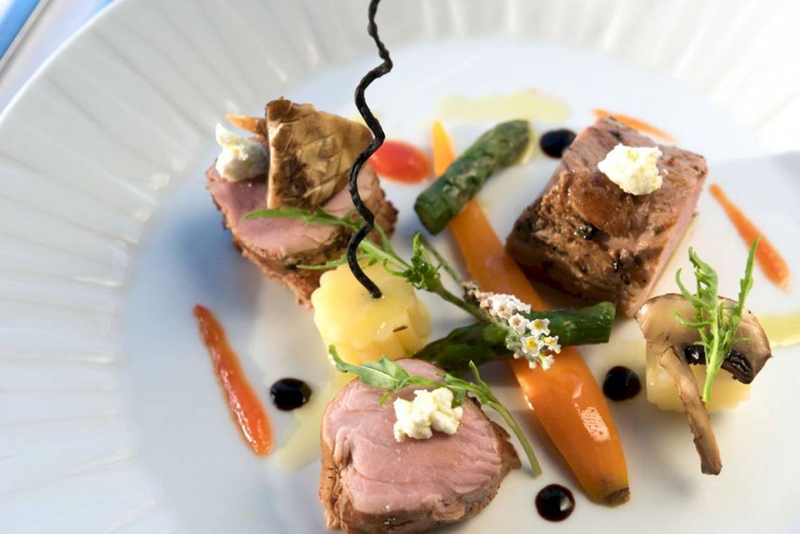 Essen auf einem Teller im Aquila Porto Rethymno Hotel, bestehend aus Fleisch, Gemüse und Beilagen.