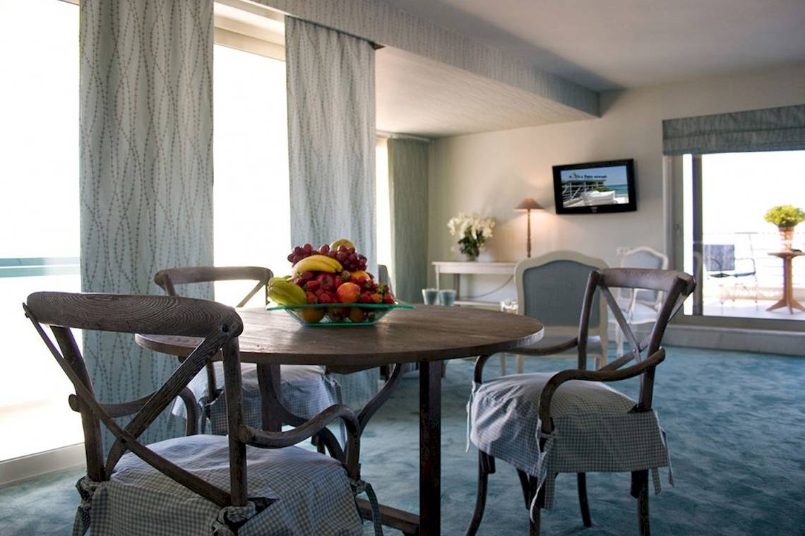 Ein Hotelinnenbereich mit einem runden Tisch, gefüllt mit Obst und mehreren Stühlen.