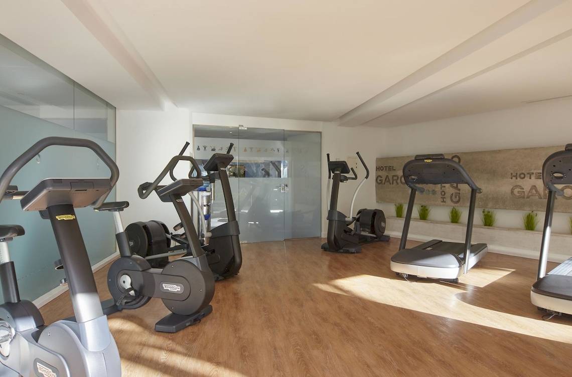 Fitnessbereich im Pure Salt Garonda Hotel mit mehreren Cardiogeräten und Sonnenlicht.