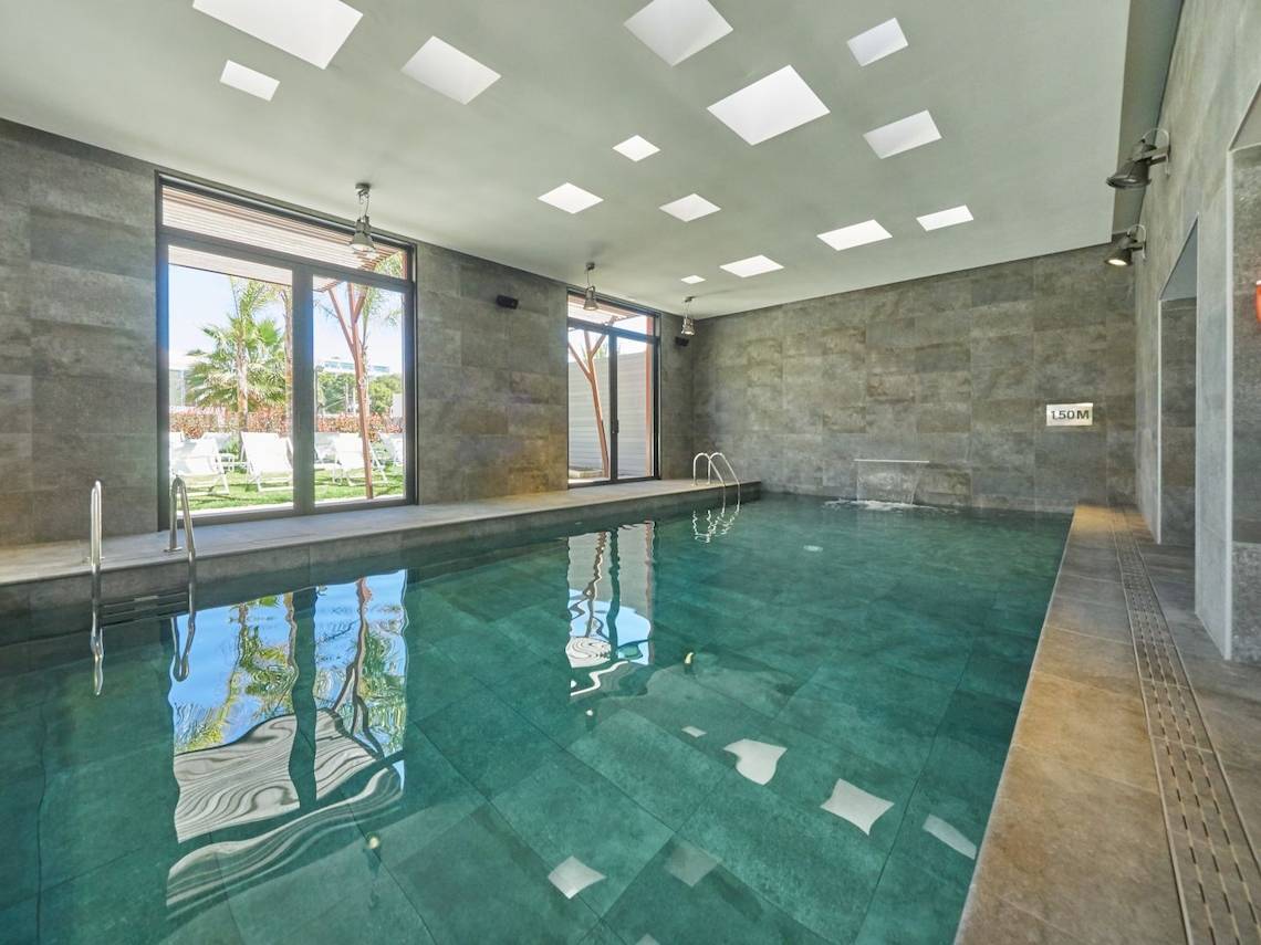 Innenpool des Pure Salt Garonda Hotels mit grünem Wasser und modernen Fliesen.
