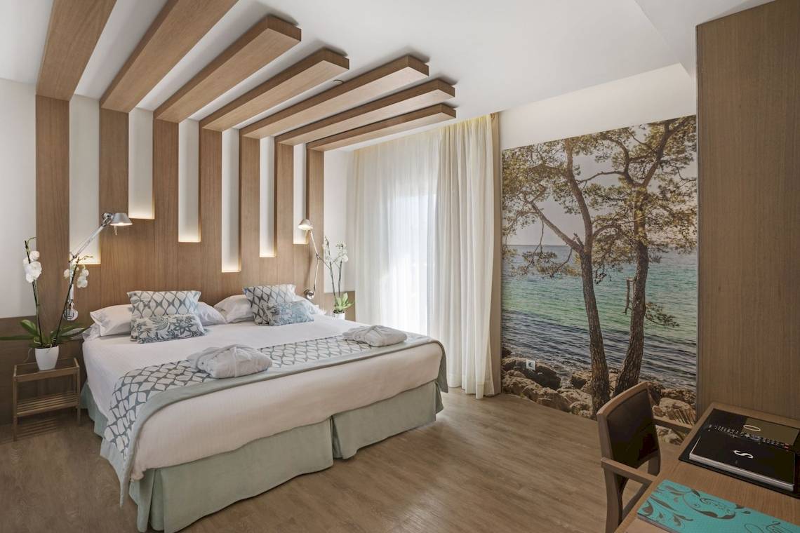 Hotelzimmer im Pure Salt Garonda mit einem großen Bett und Blick auf das Meer.