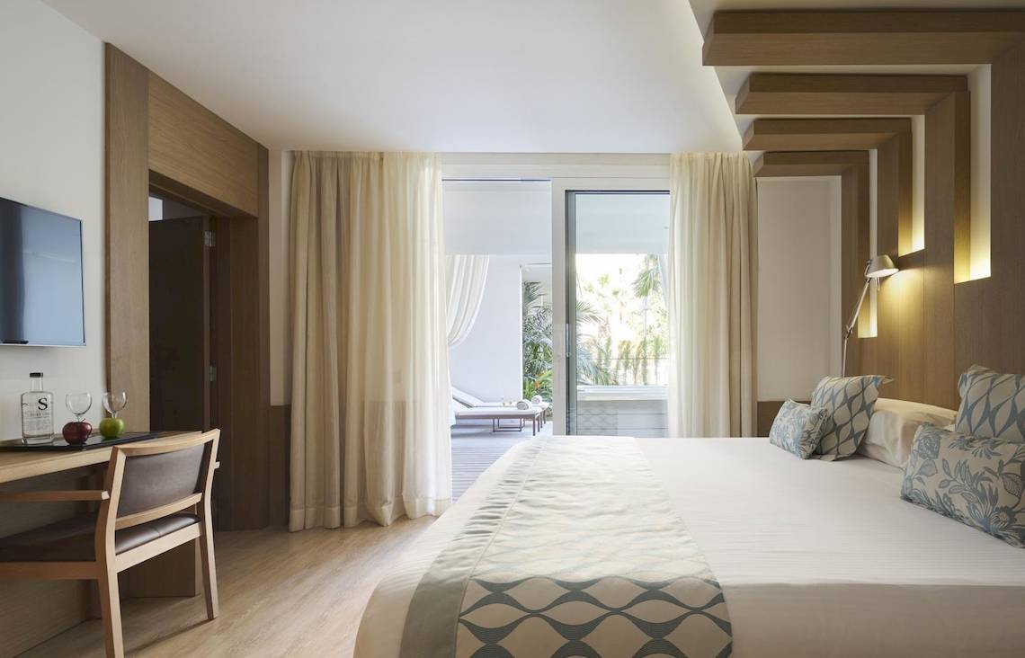 Schlafzimmer im Pure Salt Garonda Hotel mit Bett, Schreibtisch und Zugang zur Terrasse.