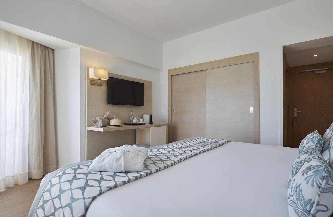 Hotelzimmer von Pure Salt Garonda mit einem Bett, Fernseher, Nachttisch und Badezimmertür.