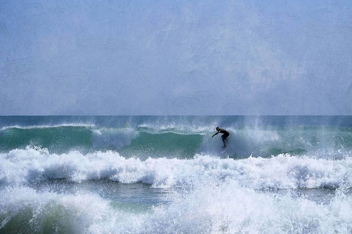 Surfer im Meer, der eine Welle reitet