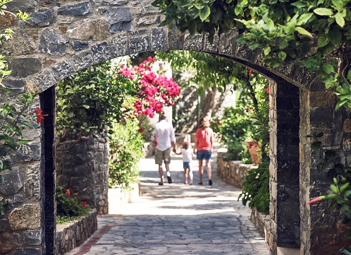 Eine Familie geht auf einem Steinweg im Ikaros Beach Hotel.
