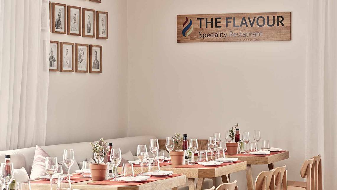 Innenbereich des The Flavour Spezialitäten Restaurant mit eingerichteten Tischen und Stühlen.